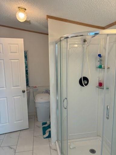 full bath featuring ornamental molding, toilet, a shower stall, and a textured ceiling