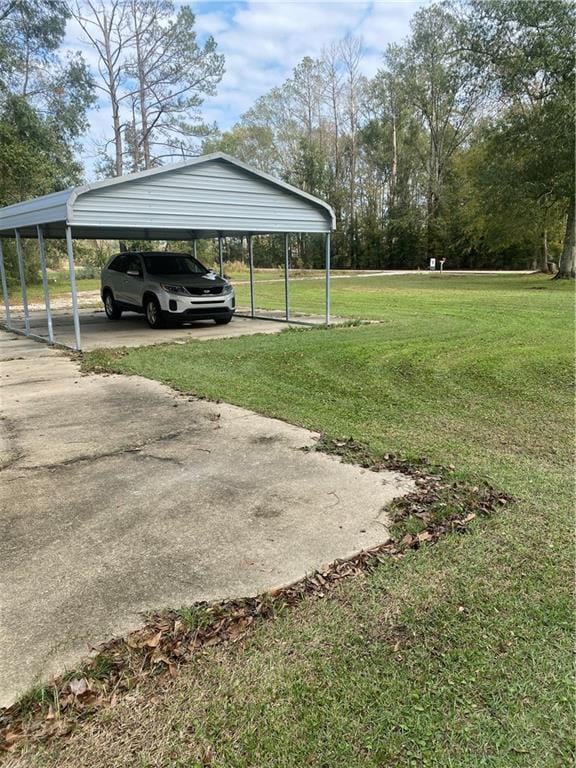 view of yard featuring a detached carport and driveway