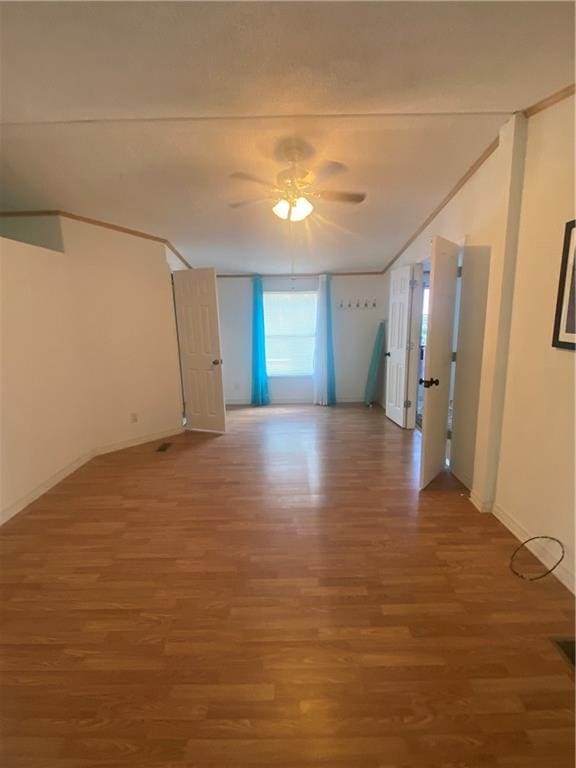 spare room featuring ceiling fan, baseboards, and wood finished floors