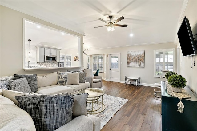 living room with ceiling fan, ornamental molding, dark wood finished floors, and baseboards