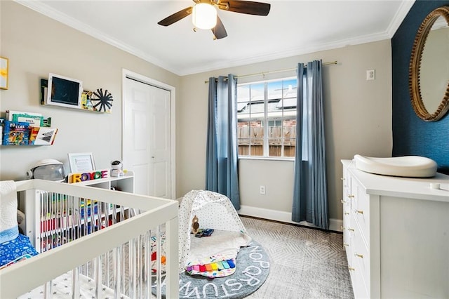 bedroom with a closet, ornamental molding, a ceiling fan, a nursery area, and baseboards