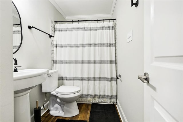 bathroom featuring toilet, wood finished floors, baseboards, ornamental molding, and a shower with curtain