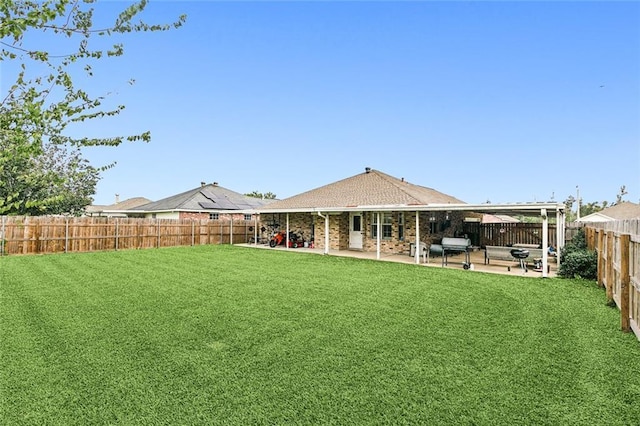 back of house with a patio, a yard, and a fenced backyard