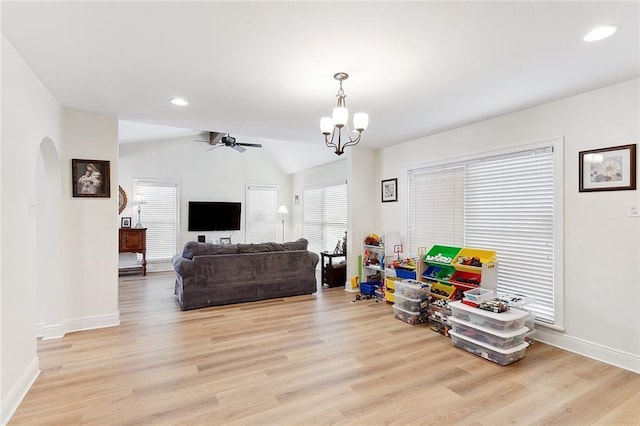 10053 Joel Ave, River Ridge, LA 70123 - living room featuring lofted ceiling, ceiling fan with notable chandelier, baseboards, arched walkways, and light wood-style floors