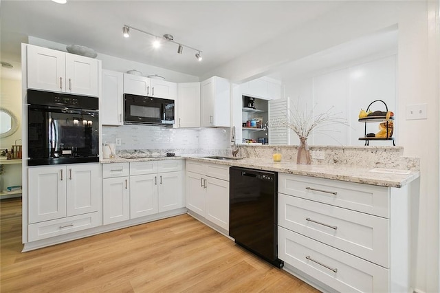 10053 Joel Ave, River Ridge, LA 70123 - kitchen featuring decorative backsplash, white cabinetry, a sink, light wood-style floors, and black appliances