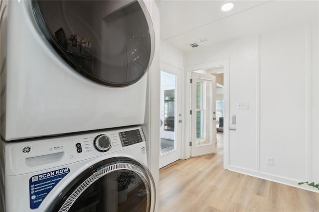 10053 Joel Ave, River Ridge, LA 70123 - clothes washing area featuring light wood-style floors, stacked washer / dryer, and laundry area
