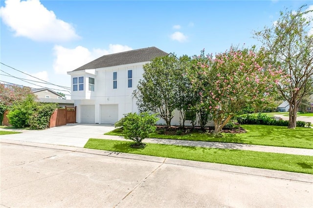 10053 Joel Ave, River Ridge, LA 70123 - view of front facade with stucco siding, a front yard, driveway, and a garage