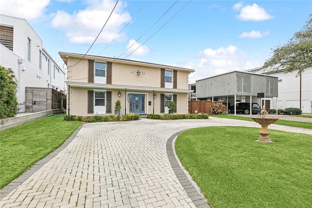 view of front of house with fence, a front lawn, and stucco siding