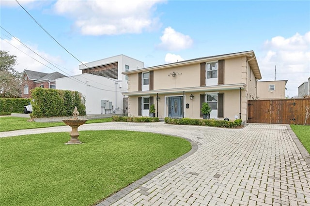 view of front facade featuring a front lawn, fence, a gate, and stucco siding