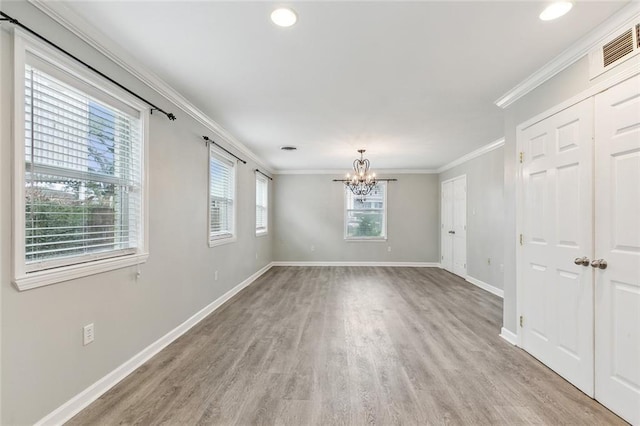 spare room with visible vents, crown molding, light wood-style flooring, and baseboards