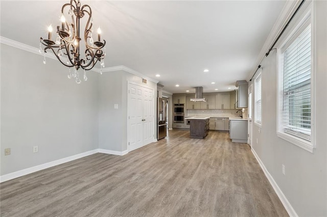 kitchen with a kitchen island, open floor plan, light countertops, appliances with stainless steel finishes, and pendant lighting