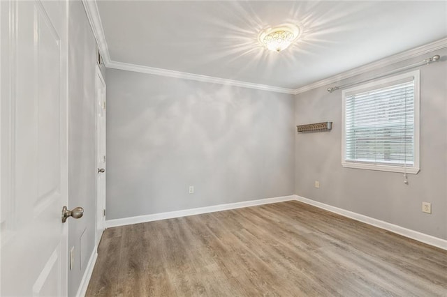 unfurnished room featuring baseboards, ornamental molding, and wood finished floors