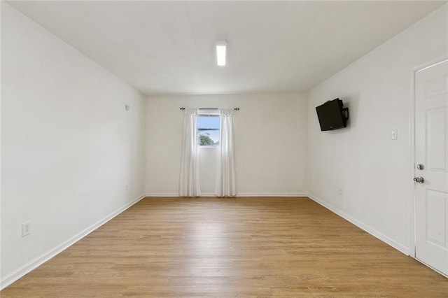 spare room with light wood-style flooring and baseboards