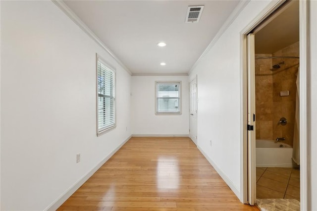 corridor with crown molding, recessed lighting, visible vents, light wood-style flooring, and baseboards