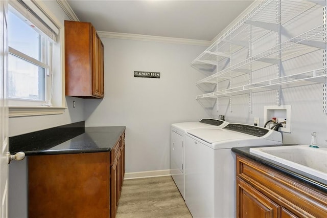 laundry room featuring crown molding, cabinet space, light wood-type flooring, independent washer and dryer, and baseboards