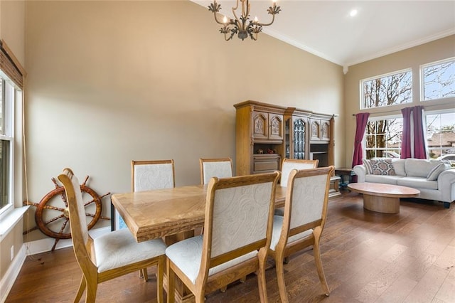 dining room with high vaulted ceiling, baseboards, ornamental molding, dark wood finished floors, and an inviting chandelier