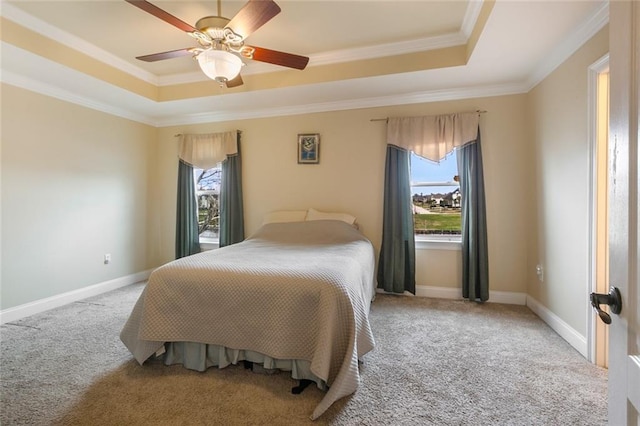 bedroom featuring light carpet, multiple windows, and a raised ceiling