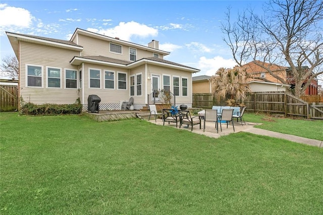 back of property featuring a yard, a fenced backyard, a chimney, and a patio