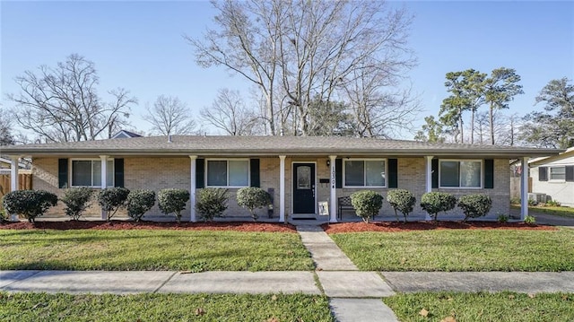 single story home with a porch, brick siding, and a front lawn