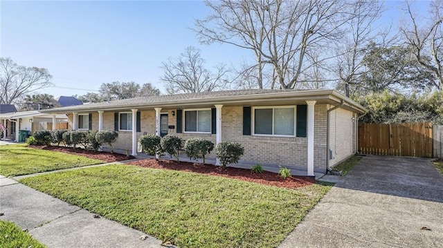 single story home featuring covered porch, brick siding, fence, and a front lawn