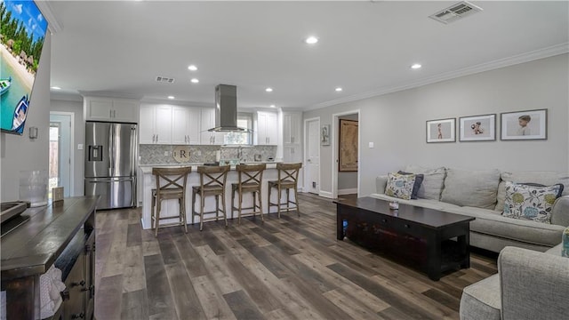 living area featuring recessed lighting, visible vents, dark wood-type flooring, and ornamental molding