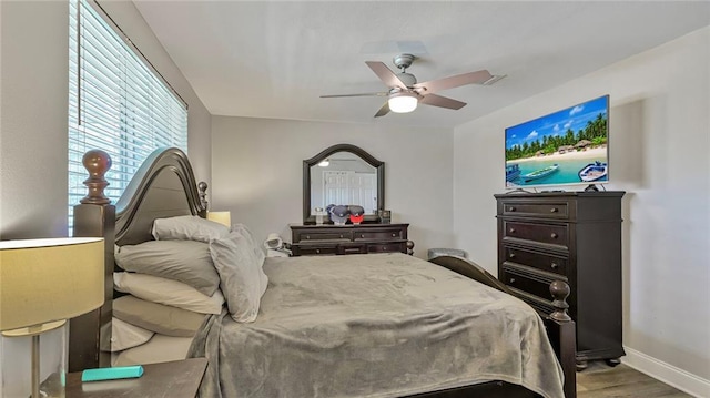 bedroom featuring ceiling fan, baseboards, and wood finished floors