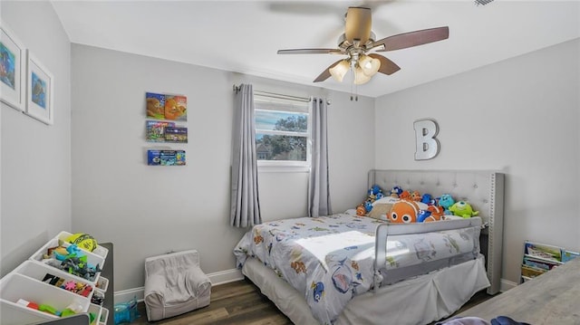 bedroom featuring ceiling fan, dark wood-style flooring, and baseboards