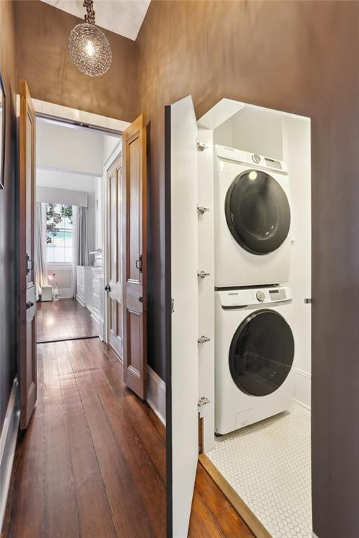 717 Port St, New Orleans, LA 70117 - laundry room with dark wood finished floors, stacked washer / dryer, and laundry area