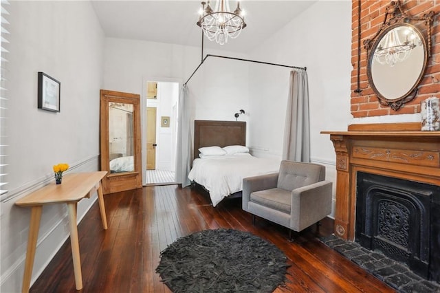 717 Port St, New Orleans, LA 70117 - bedroom featuring wood-type flooring, a notable chandelier, and a fireplace