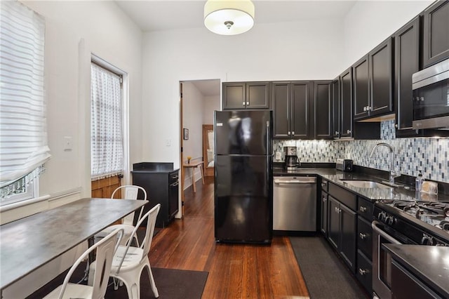 717 Port St, New Orleans, LA 70117 - kitchen featuring dark countertops, stainless steel appliances, dark wood-type flooring, and a sink