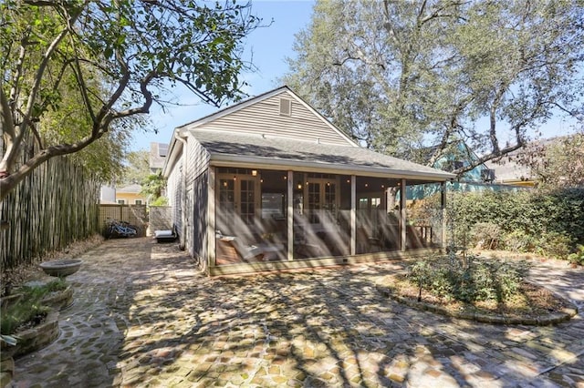 717 Port St, New Orleans, LA 70117 - back of house with fence, a sunroom, and roof with shingles