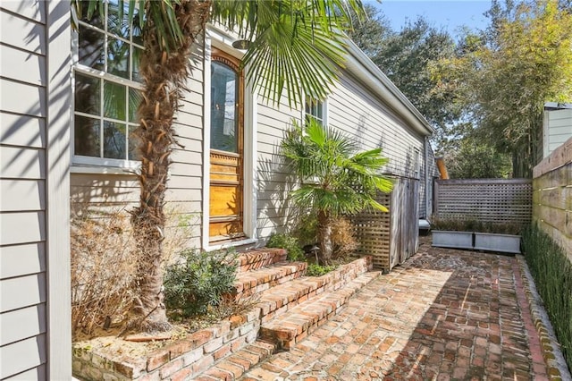 view of property exterior with a patio area and fence