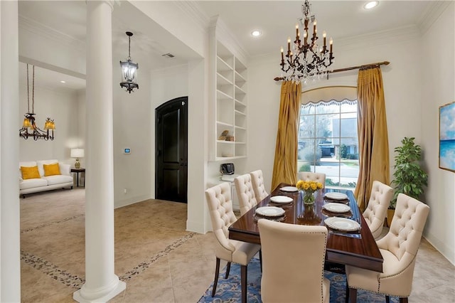 dining room featuring built in features, a chandelier, crown molding, and ornate columns