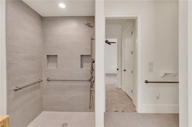 bathroom featuring a ceiling fan, tile patterned flooring, tiled shower, and baseboards