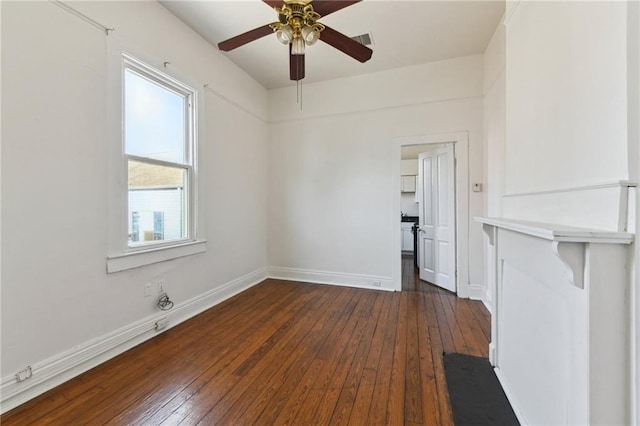 spare room with dark wood-style floors, ceiling fan, visible vents, and baseboards