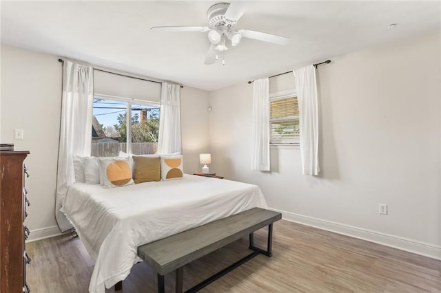 bedroom featuring a ceiling fan, baseboards, and wood finished floors