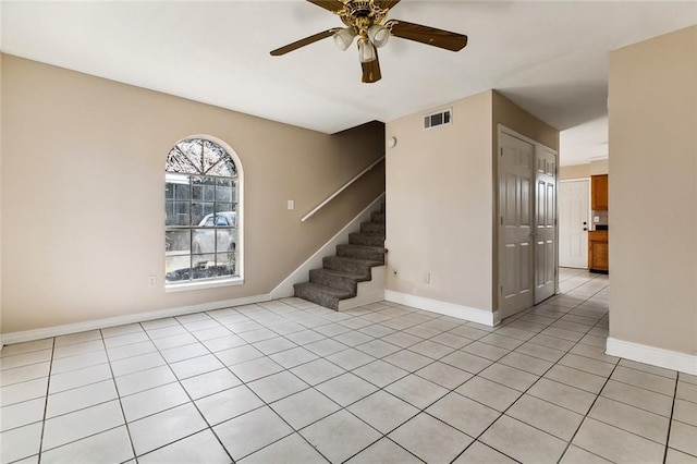 unfurnished room featuring stairway, light tile patterned flooring, visible vents, and baseboards