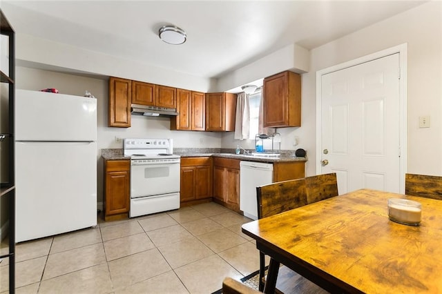 kitchen featuring dark countertops, white appliances, brown cabinets, and under cabinet range hood