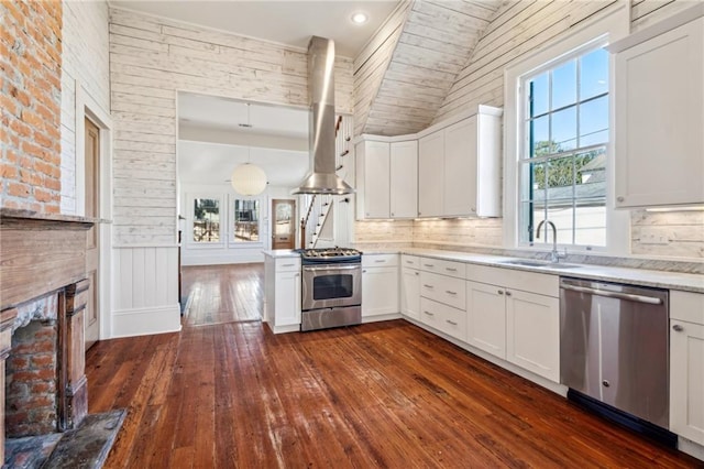 kitchen with stainless steel appliances, white cabinets, light countertops, and decorative light fixtures