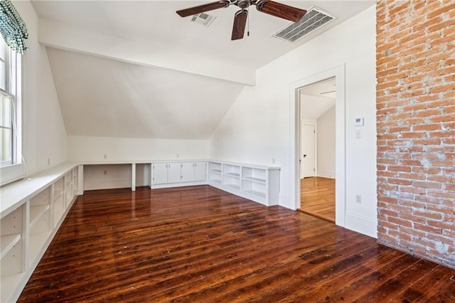 additional living space with lofted ceiling with beams, dark wood-style floors, and visible vents