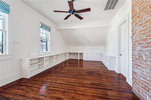 bonus room with vaulted ceiling with beams, brick wall, visible vents, a ceiling fan, and dark wood-style floors