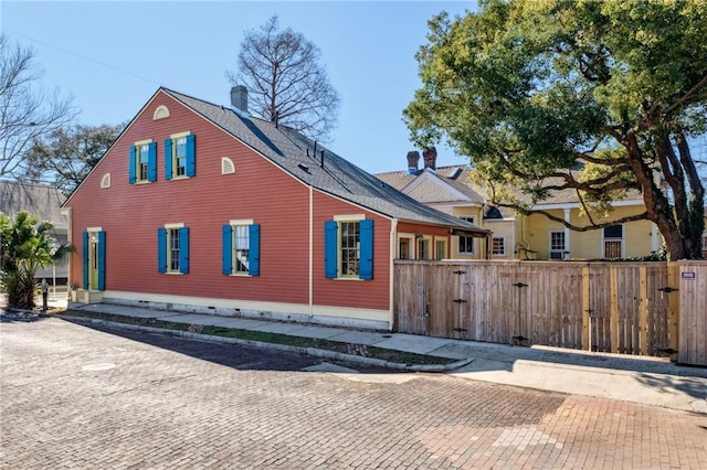 view of front of home featuring a gate, a chimney, and fence