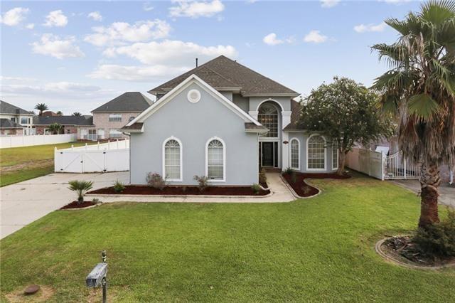 view of front of house with concrete driveway, a front lawn, fence, and a gate