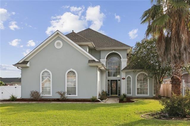 view of front facade featuring a gate, a front lawn, and stucco siding