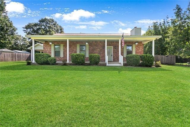 view of front of home with a front yard, fence, and brick siding