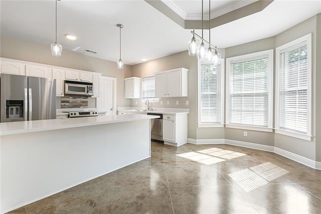 kitchen with light countertops, white cabinets, baseboards, and stainless steel appliances