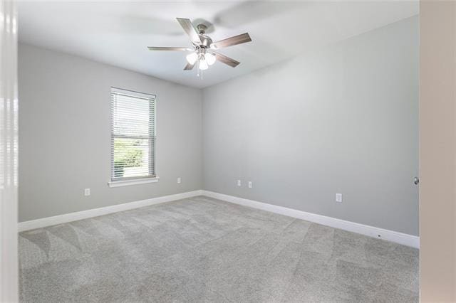 unfurnished room with a ceiling fan, light colored carpet, and baseboards