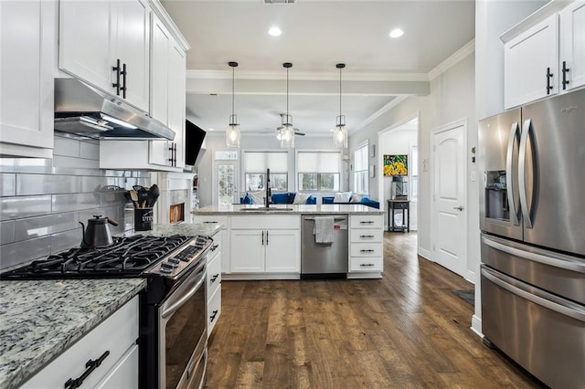 kitchen featuring pendant lighting, appliances with stainless steel finishes, white cabinets, a sink, and under cabinet range hood