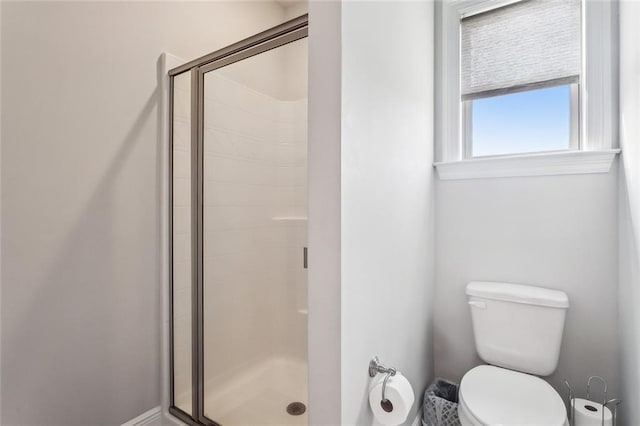 full bathroom featuring a stall shower and toilet