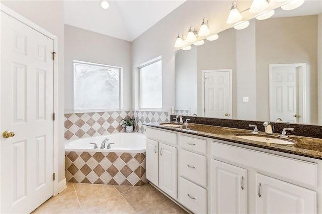 full bathroom with lofted ceiling, double vanity, tile patterned flooring, and a sink